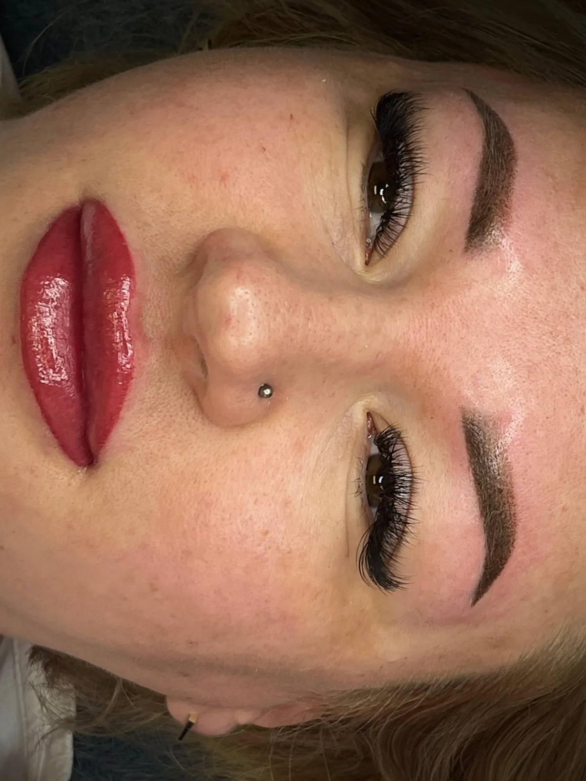 Permanent lip makeup in a bold shade, plus brows